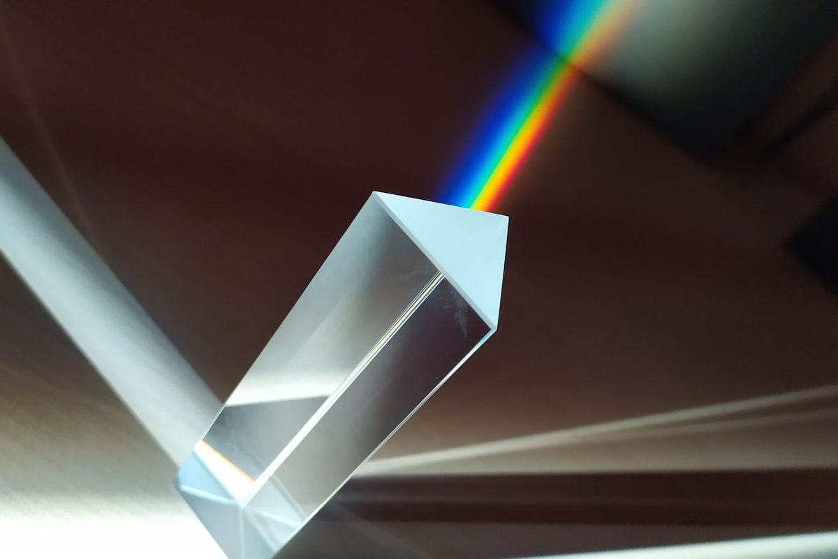 Glass prism splitting a beam of light into a rainbow