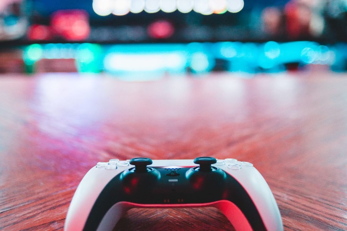 White game controller lying on a red wooden table