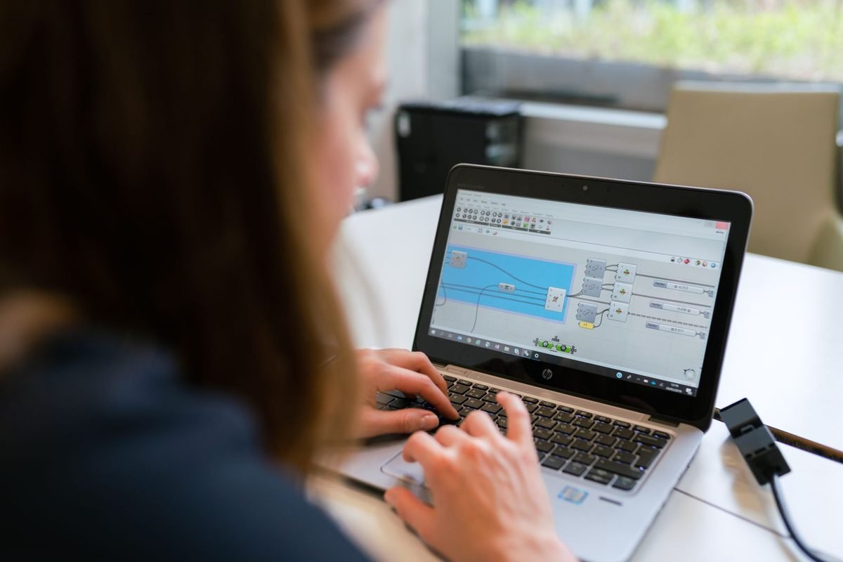 Person typing on a laptop that shows software on screen
