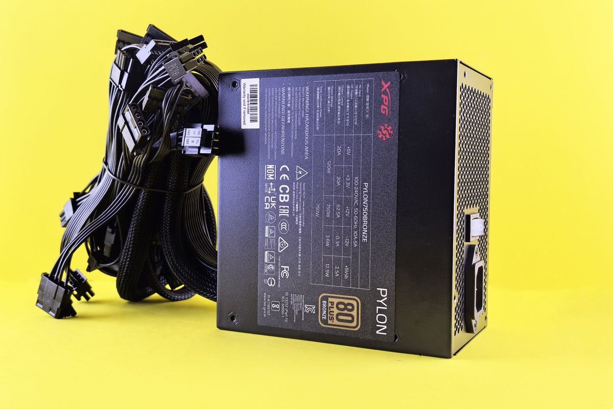 Black computer power supply unit with cables on a yellow background