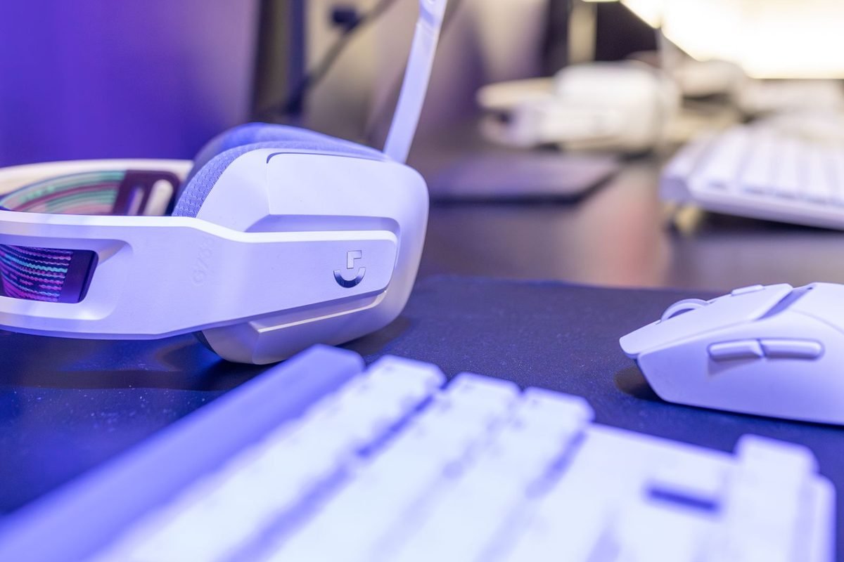 White gaming headset and keyboard under purple lighting