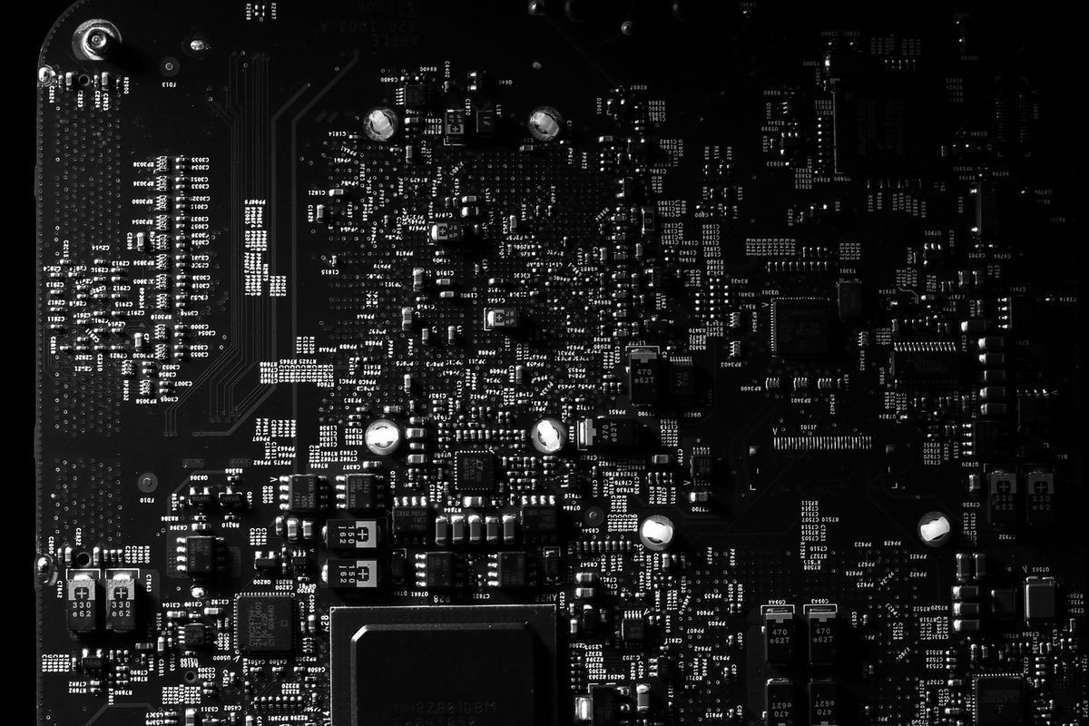 Black and white close-up of a dense circuit board with tiny components