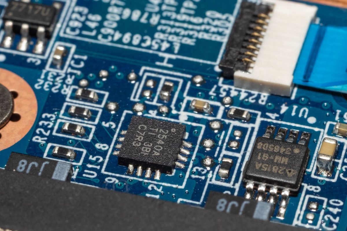 Blue circuit board with chips and a flat cable connector