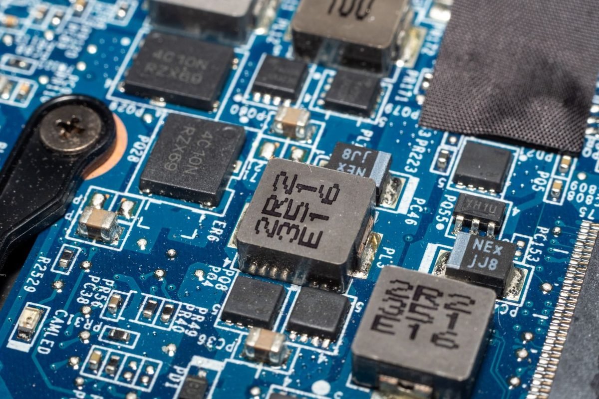Close-up of chips and inductors on a blue circuit board
