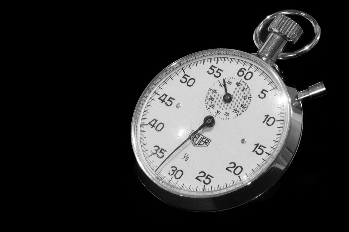 Vintage mechanical stopwatch with a black and white dial against a dark background
