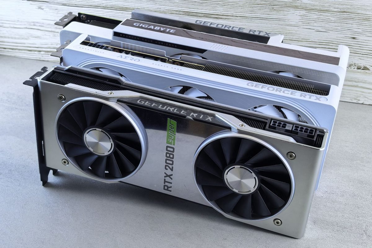 Several NVIDIA GeForce RTX graphics cards stacked on a grey surface