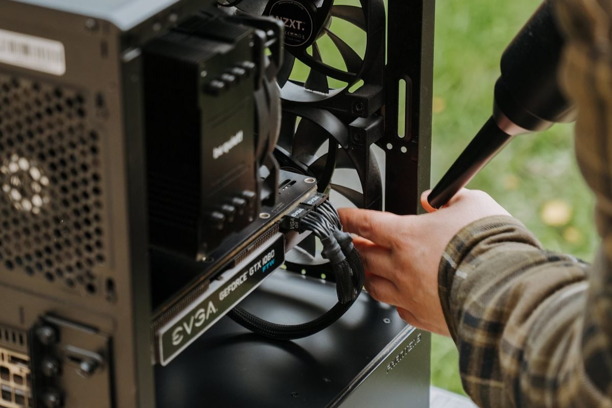 Hand plugging a power cable into a graphics card inside a computer case