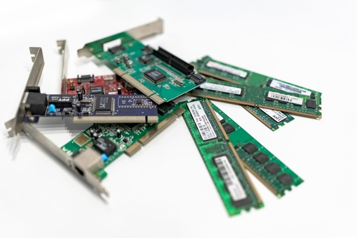 Computer memory modules and expansion cards arranged on a white surface