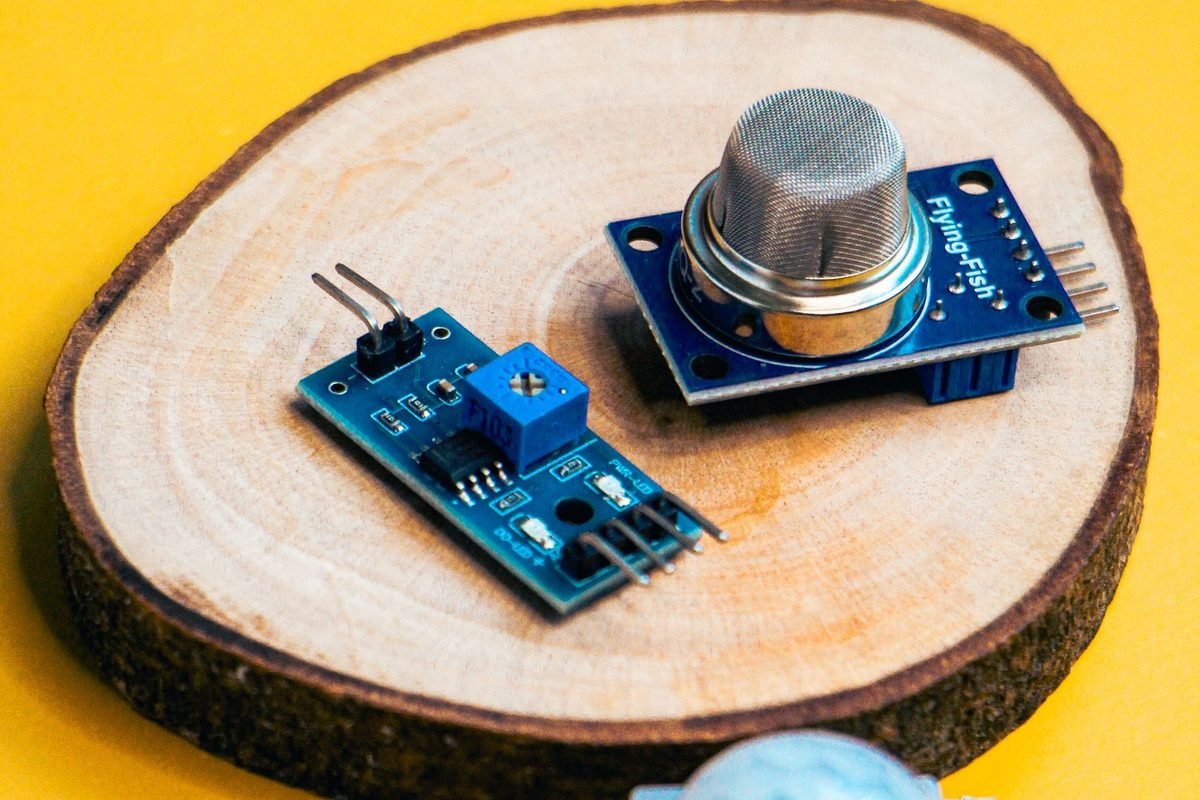 Small electronic sensor modules on a wooden slice with a yellow background