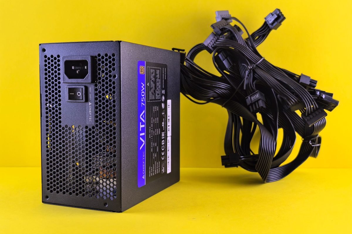 Black 750W power supply with cables on bright yellow background