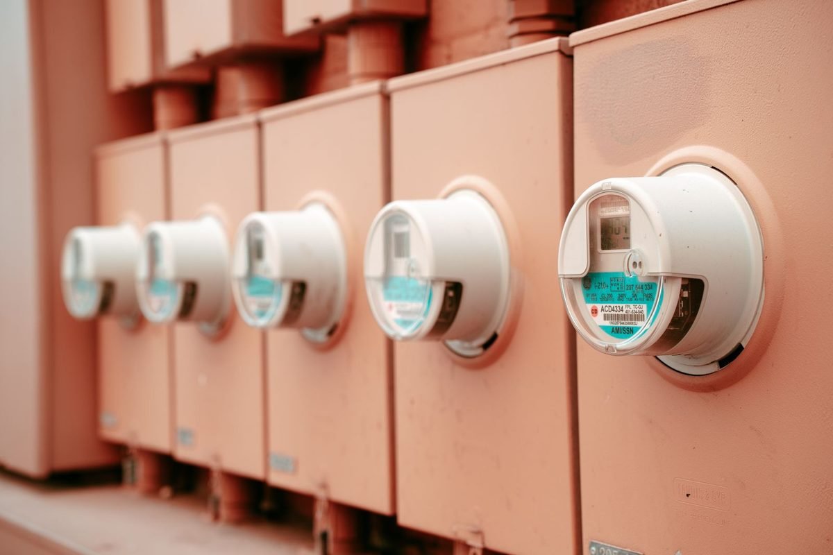 Row of residential electricity meters on a pink wall